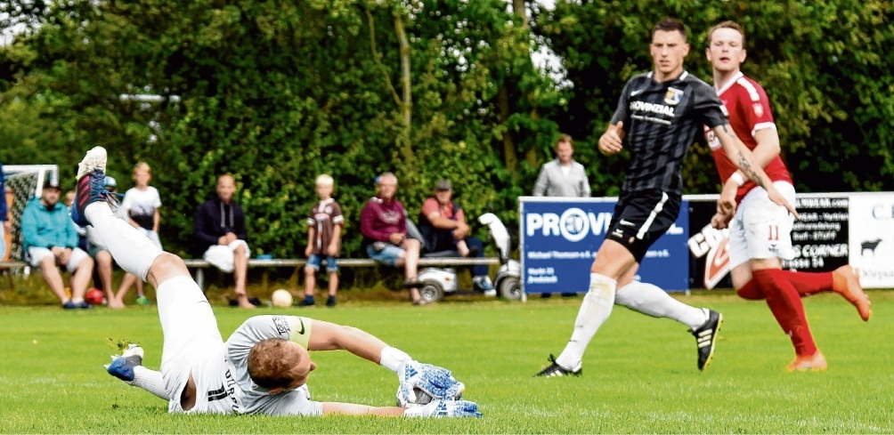 Sichere Beute: Dörpums Torhüter Eik Sönksen (li.) hat diesen Ball sicher, sein Abwehrspieler Tim Borchardt und Niebülls Stürmer Morten Höfer (re.) schauen zu.